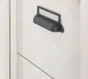 A close-up shot of a drawer handle on a white wooden cabinet. Produktbild-Vorschau