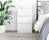 A white three-drawer nightstand next to a bed. Podgląd zdjęcia produktu