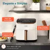 A white air fryer is shown on a kitchen counter, with text overlays highlighting its features. Shelves with bowls and a plant are visible in the background. Náhľad obrázku produktu