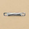 A close-up shot of a metal picture frame hanging hardware on a brown background. Anteprima dell’immagine prodotto