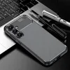 A smartphone case with a carbon fiber look is placed on a laptop keyboard, with two pens nearby. Produktbild-Vorschau