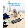 A power bank is shown charging multiple devices, including a tablet and two smartphones, on a wooden table. Anteprima dell’immagine prodotto