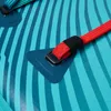 A close-up view of a paddleboard's attachment point with a red bungee cord. Produktbild-Vorschau