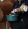 A person is pouring a liquid from a bottle into a green bowl, with a horse in the background. Anteprima dell’immagine prodotto