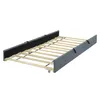 A roll-out bed frame with wooden slats and a grey fabric border, shown from a diagonal angle against a white background. Náhled obrázku produktu