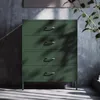 A green metal dresser with four drawers is shown in a room with a concrete wall and sunlight casting shadows. Anteprima dell’immagine prodotto