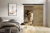 A bedroom scene featuring a sliding door, bed, and artwork. Náhled obrázku produktu