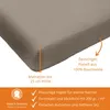 A close-up of a taupe fitted sheet, with text overlays and icons indicating product features and origin. Produktbild-Vorschau