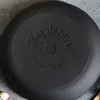 The underside of a black cast iron pan with embossed text. Produktbild-Vorschau