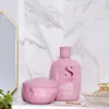 A pink shampoo bottle and a pink hair mask are displayed on a shelf with a marble background. Voir les images du produit