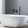 A modern bathroom with a white freestanding bathtub and black wall-mounted faucets. Podgląd zdjęcia produktu