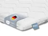 A close-up of a white mattress topper with labels attached. Náhled obrázku produktu