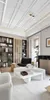 A modern living room with a sofa, armchair, coffee table, and bookshelves. Náhľad obrázku produktu