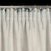 A close-up view of the top of a curtain, showing the pleats and the curtain rod. Produktbild-Vorschau