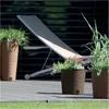 A lounge chair and planters on a deck. Produktbild-Vorschau