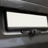 A close-up view of a car's license plate area, showing a blank license plate and a backup camera mounted below it. Produktbild-Vorschau