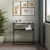 A console table is placed against a wall with artwork above it and a plant to the side. Náhled obrázku produktu