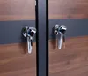 A close-up view of two metal handles with keys inserted on a wooden surface. Produktbild-Vorschau