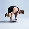A man is performing a balance exercise on a balance board. Produktbild-Vorschau