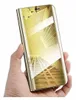 A hand holding a gold flip phone case with a clear view mirror. Produktbild-Vorschau