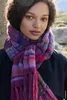 A woman wearing a colorful knitted scarf outdoors. Produktbild-Vorschau