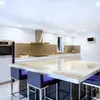 A modern kitchen with a large marble island and bar stools. Anteprima dell’immagine prodotto