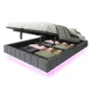 A bed frame with its storage compartment open, revealing folded linens and blankets. The bed frame has integrated LED lighting along its base. Náhľad obrázku produktu