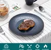 A table setting with a steak on a plate, cutlery, and a jar of cookies. Voir les images du produit