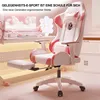 A pink and white gaming chair with a footrest extended, set up in a room with a desk and computer. Anteprima dell’immagine prodotto