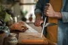 A person is sharpening a knife on a honing steel in a kitchen. Voir les images du produit
