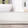 A close-up of a white bath mat in a bathroom setting. Produktbild-Vorschau