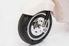 Close-up of the front wheel and suspension of a white electric scooter. Podgląd zdjęcia produktu