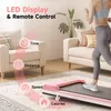 A woman is running on a pink treadmill in a living room. The treadmill has an LED display and remote control, and features like time, distance, speed, and calories are highlighted with icons and text. Produktbild-Vorschau