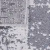 A close-up view of a rug with a textured, abstract pattern in gray and white. Produktbild-Vorschau