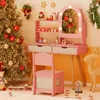 A pink children's vanity set with a mirror, drawers, and chair, decorated for Christmas with a tree, ornaments, and festive figures. Podgląd zdjęcia produktu
