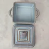 A top-down view of a square ceramic baking dish and its lid, both with a light blue glaze and brown trim. Náhled obrázku produktu