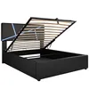 A black upholstered bed frame with the mattress support slats lifted, revealing storage space underneath. Blue LED lights are integrated into the headboard. Produktbild-Vorschau