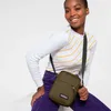 A woman is posing with a green Eastpak crossbody bag. Anteprima dell’immagine prodotto
