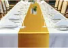 A long dining table set for a formal event with white tablecloths and a gold runner. Anteprima dell’immagine prodotto