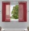 A window with red sheer curtains, overlooking a green tree and blue sky. Produktbild-Vorschau