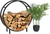 A black metal firewood rack filled with logs, next to a potted green plant. Náhľad obrázku produktu