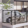 A balcony with a railing, seating, and a plant. Produktbild-Vorschau