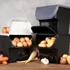 Two stacked storage containers for vegetables, with various vegetables like onions, potatoes, carrots, garlic, and apples displayed around them. Anteprima dell’immagine prodotto