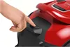 A hand is pressing a button on a red and black vacuum cleaner. Anteprima dell’immagine prodotto