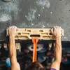 Trainingsboard 'VerticalBoard One' von YY Vertical; montiert an einer Kletterwand; mit zwei Händen; die die Griffe halten. Produktbild-Vorschau