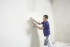 A man is plastering a wall in a room. Produktbild-Vorschau