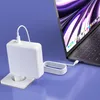 A white laptop charger and cable are plugged into a laptop. Podgląd zdjęcia produktu