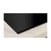 A close-up view of a black induction hob set into a countertop. Podgląd zdjęcia produktu