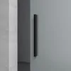 A black handle on a glass door. Produktbild-Vorschau