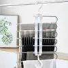 Weißer mehrstöckiger Hosenbügel mit silbernen Metallstangen, der mehrere Hosenpaare an einer silbernen Kleiderstange hält Náhľad obrázku produktu